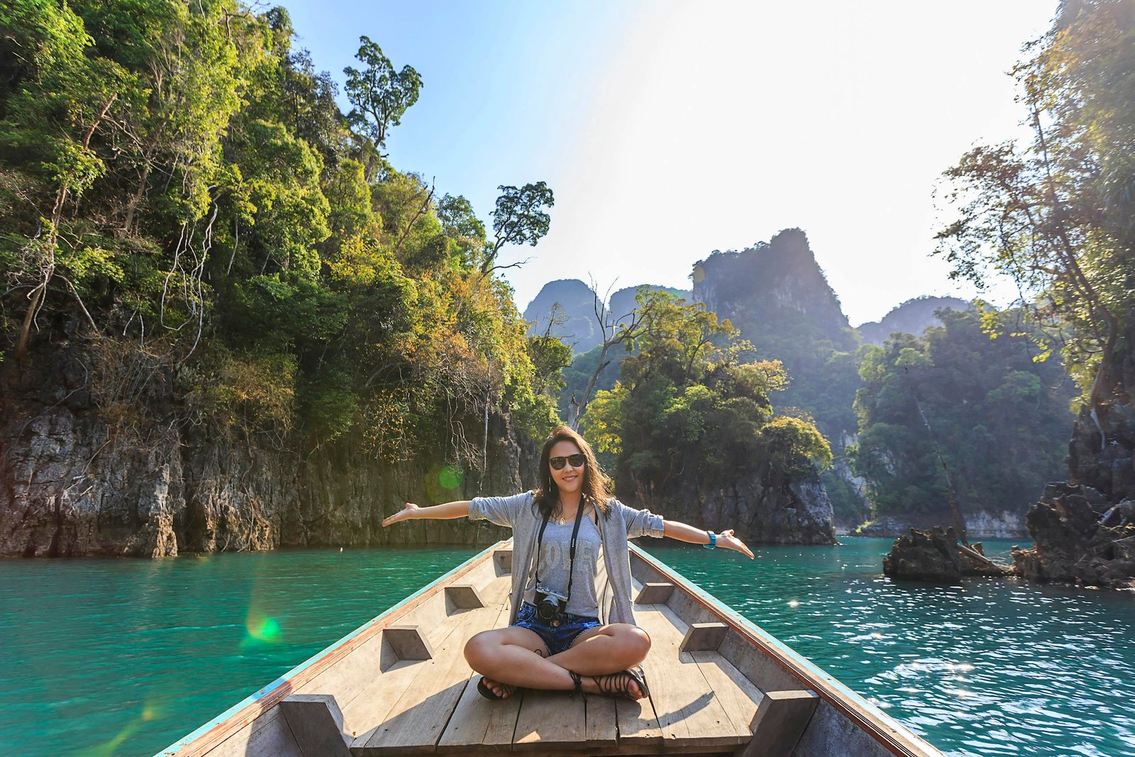 Woman enjoying the freedom of a remote work lifestyle on a boat in a tropical location, showcasing how to become a digital nomad.